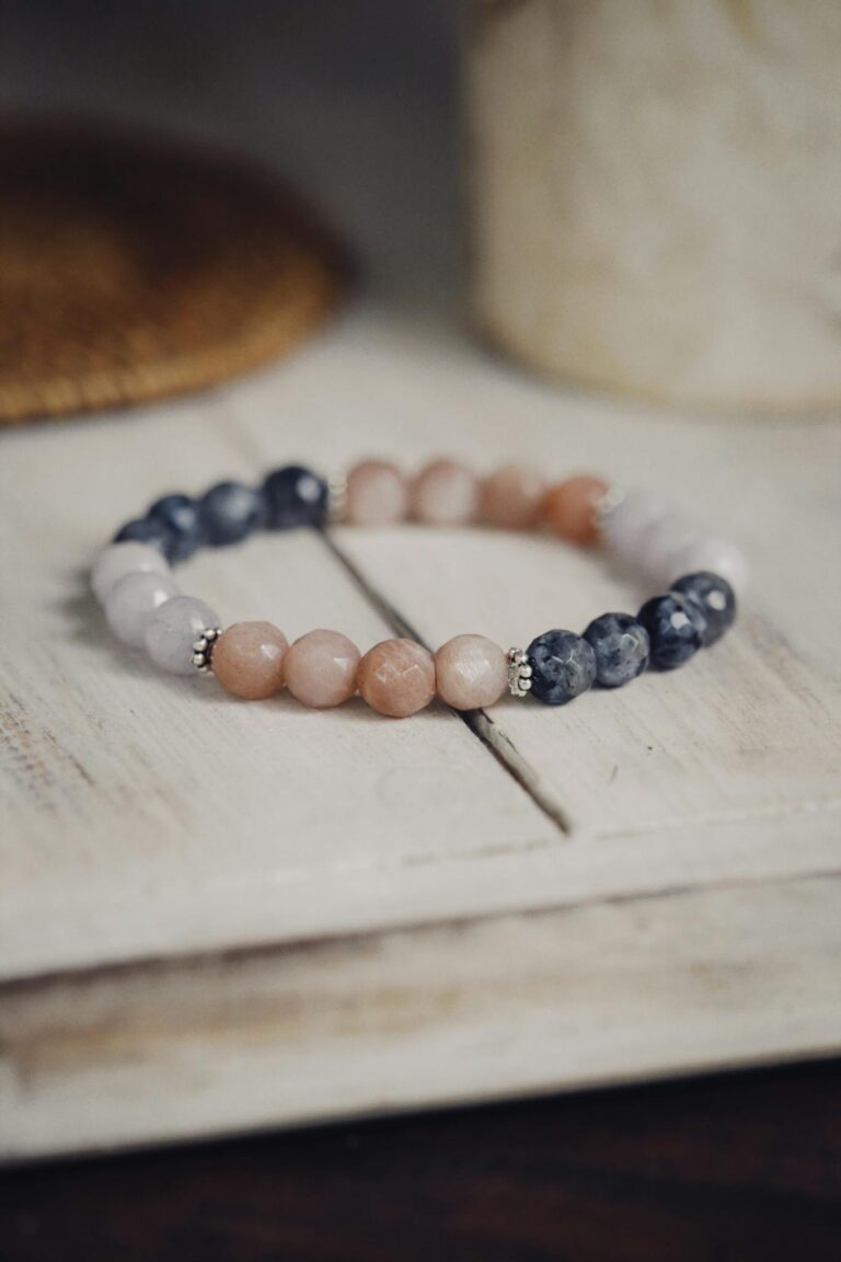 Close-up of a handmade stone bead bracelet elegantly placed on a wooden table, showcasing craftsmanship.