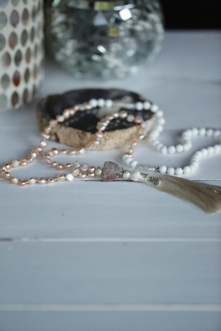 Elegant handmade necklace with pearls and stone detail on a white table.